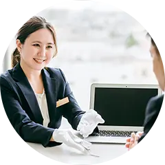 店頭買取：女性スタッフが白い手袋を着用し、顧客に対応している様子の写真